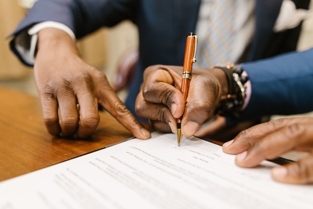 two people looking at a least contract and signing it